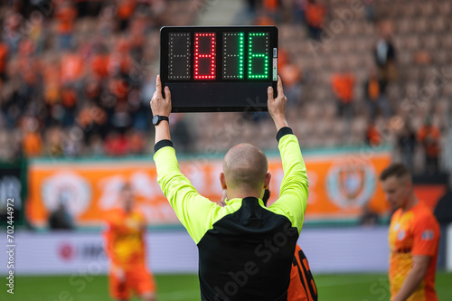 Team manager man shows players substitution during football match.