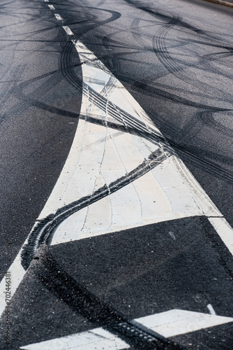 Black rubber tire marks in a street.