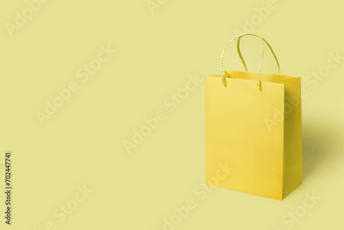 Yellow paper shopping bag on yellow background. Shopping sale delivery concept. Packaging gift.
