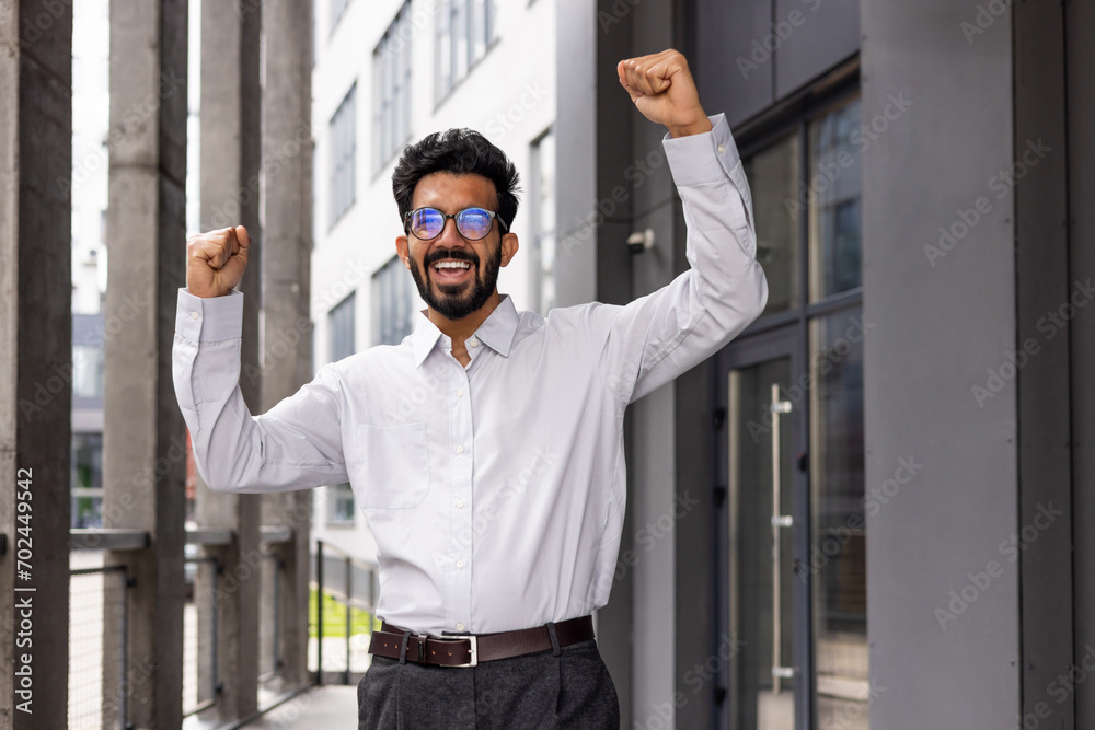 A joyful businessman dances from the outside of the office building, a satisfied man celebrates the victory of Triumph. A joyful businessman dances from the outside of the office building, a satisfied man celebrates the victory of Triumph.