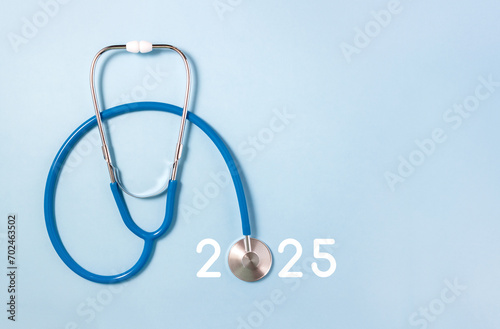 Medicine stethoscope and numbers 2025 on blue background. Concept of health care in New Year. Selective focus, copy space