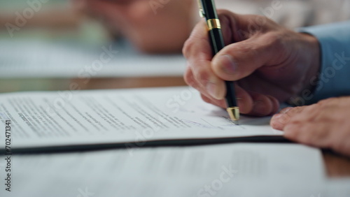 Businessman hand signing agreement negotiation table. Happy employee satisfied photo