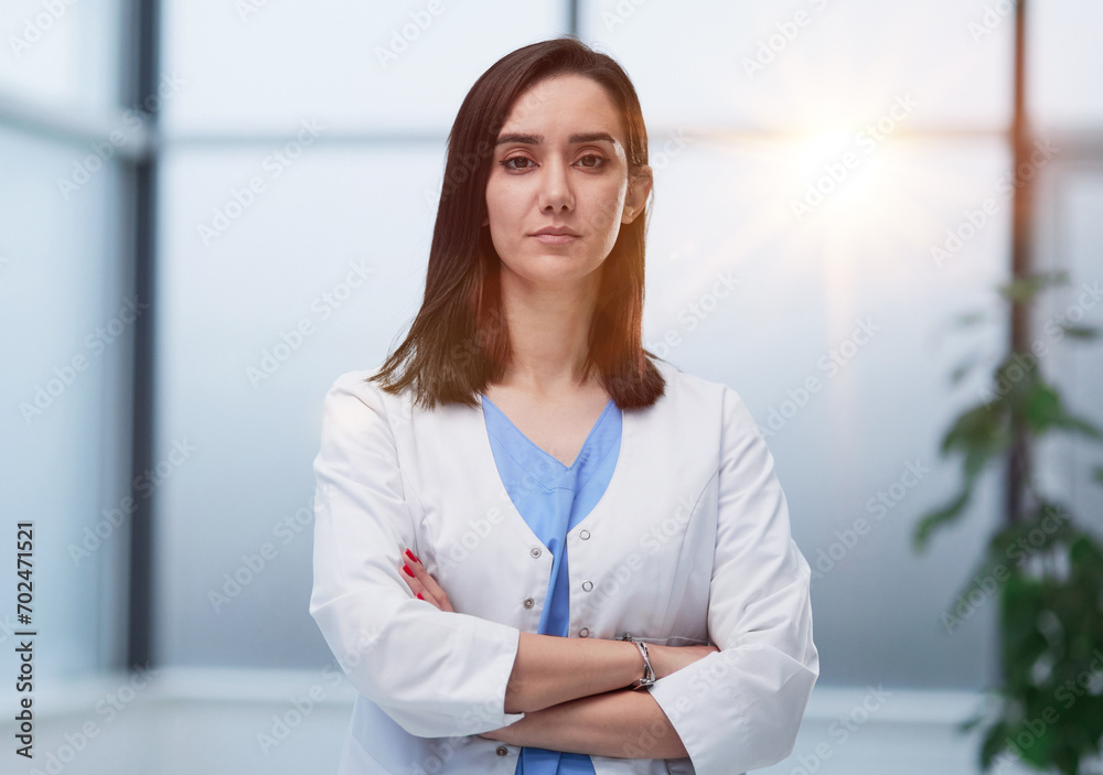 female doctor in lab coat with arms crossed against