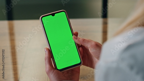 Woman hand scrolling green phone screen indoor closeup. Lady reading cellphone