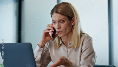 Fotografie Upset boss talking cellphone at office close up