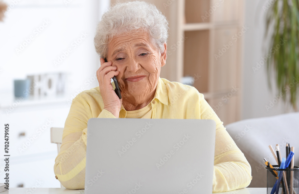 Senior woman with laptop talking by mobile phone at home Senior woman with laptop talking by mobile phone at home