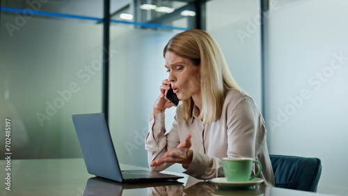 Irritated woman arguing phone workplace closeup. Furious lady disputing mobile