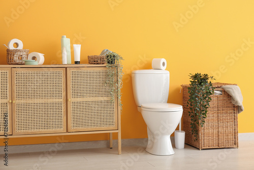 Stylish interior of modern restroom with wicker laundry basket and bath supplies