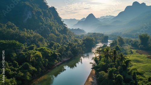 Beautiful natural scenery of river in southeast Asia tropical green forest with mountains in background, aerial view drone shot