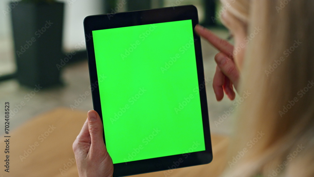 Lady finger swiping greenscreen tablet at office. Anonymous woman surfing web