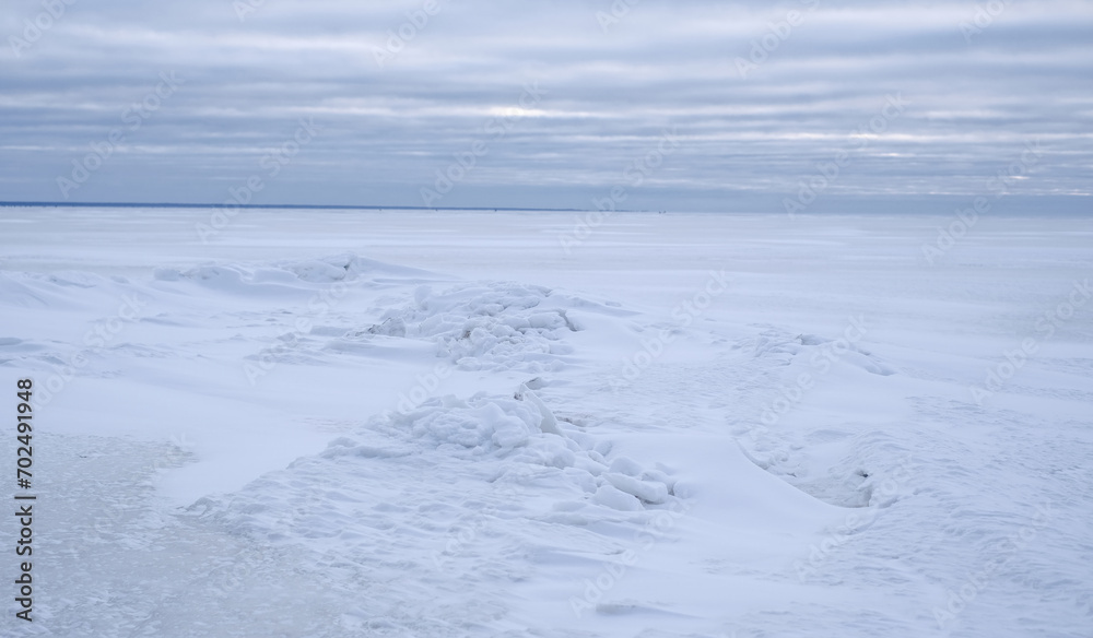 A snow covered frozen sea with a cloudy sky