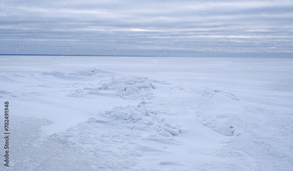 A snow covered frozen sea with a cloudy sky A snow covered frozen sea with a cloudy sky