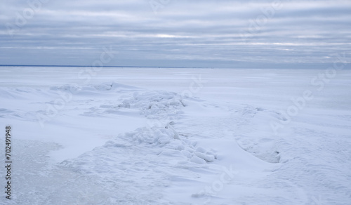 A snow covered frozen sea with a cloudy sky