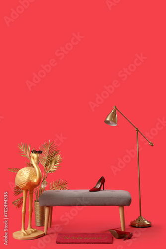 Grey bench  flamingo statue and standard lamp on red background