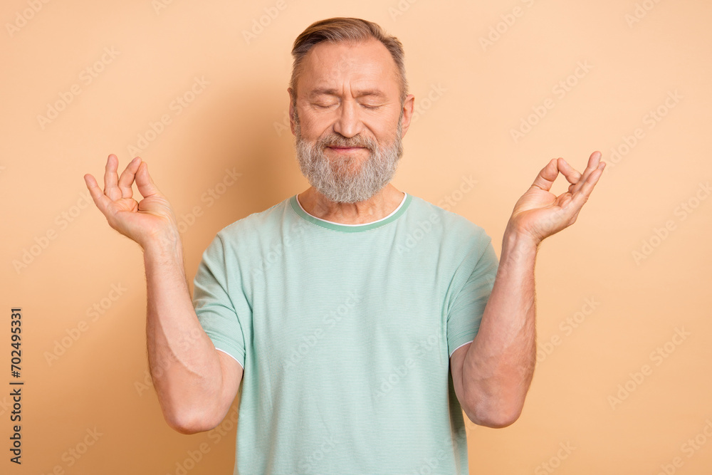 Photo of calm concentrated man wearing trendy clothes meditating practicing yoga isolated on beige color background Photo of calm concentrated man wearing trendy clothes meditating practicing yoga isolated on beige color background