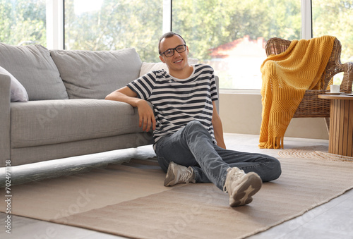 Young man sitting on floor ...