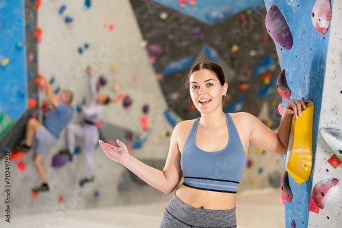 Sports positive woman climber on background of the climbing wall