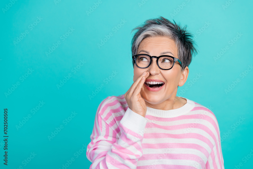 Photo of impressed tricky woman dressed pink pullover telling secret looking empty space isolated teal color background