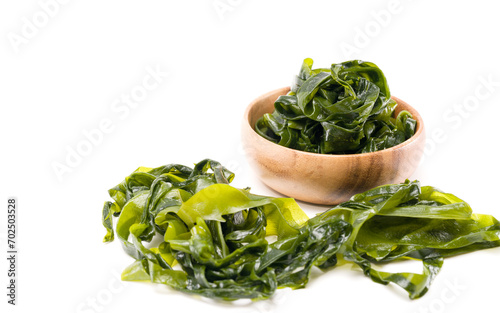 Fresh seaweed wakame in woodle bowl isolated on white background. Copy space. Japanese food photo