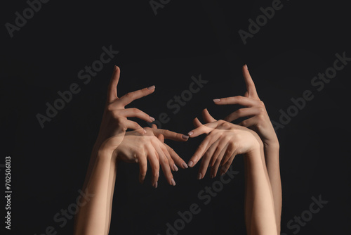 Stroboscopic photo of moving female hands on dark background