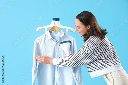 Young woman steaming wrinkl...