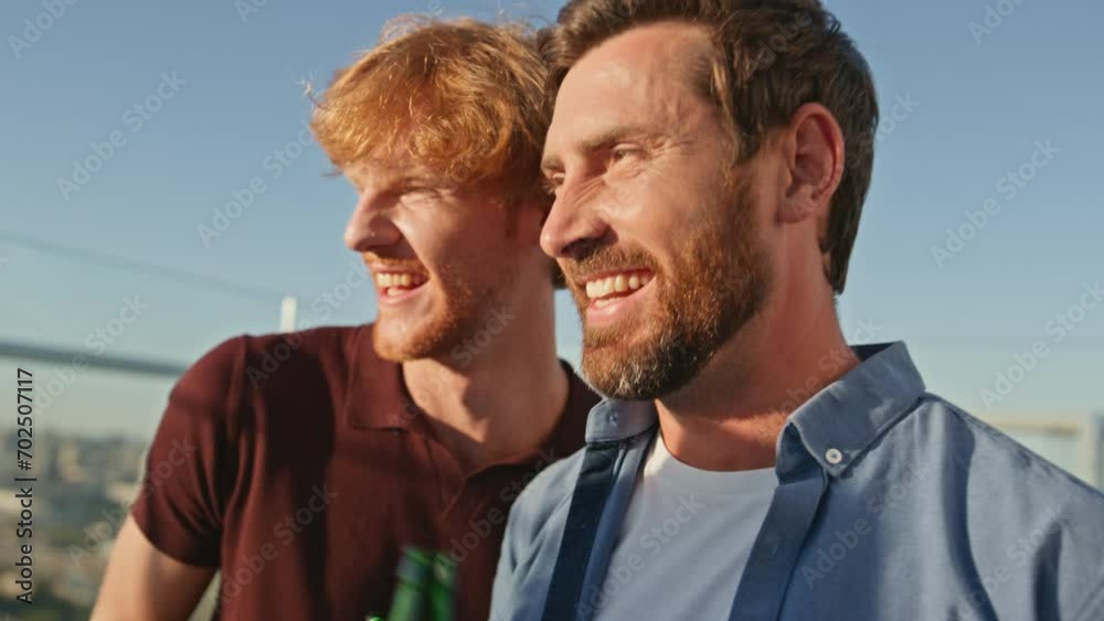 Cheerful buddies enjoy party on rooftop close up. Smiling men talking at hangout Cheerful buddies enjoy party on rooftop close up. Smiling men talking at hangout