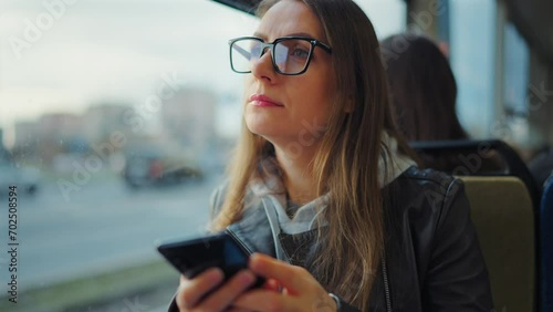 Public transport. Woman in tram using smartphone photo
