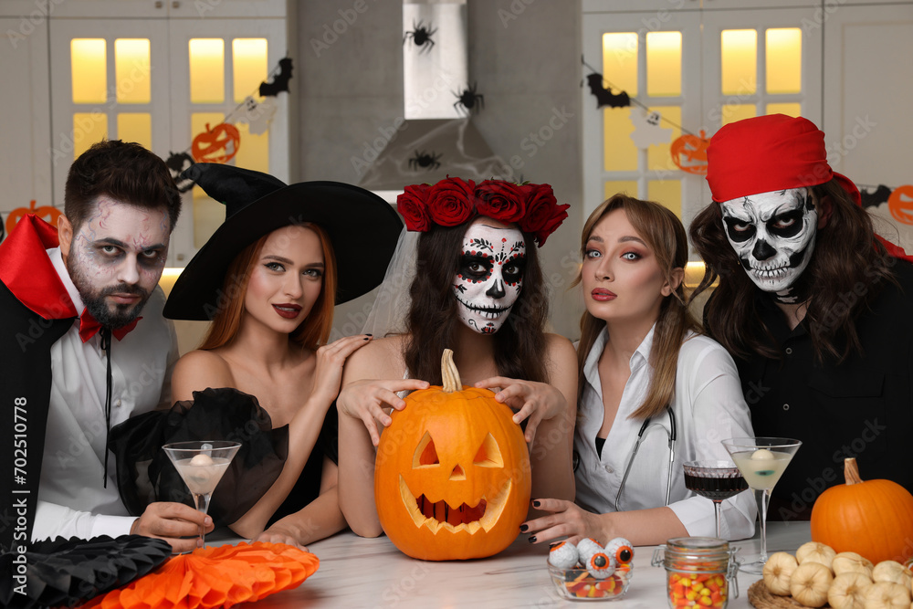 Φωτογραφία Group of people in scary costumes with cocktails and carved pumpkin celebrating
