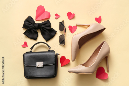 Composition with stylish high-heeled shoes, female accessories and paper hearts on color background. Valentine's Day celebration