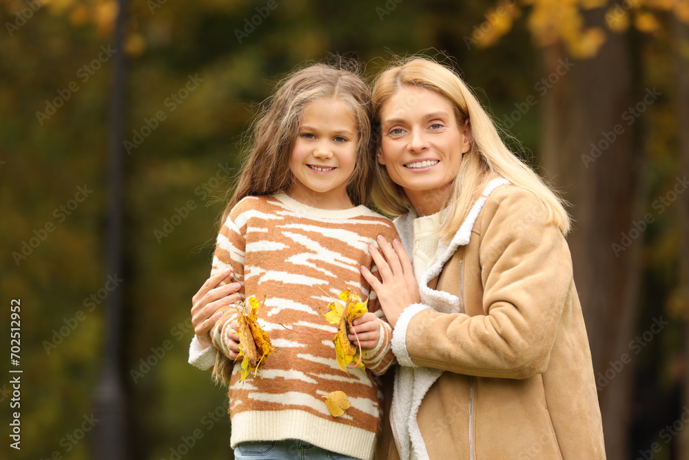 Portrait of happy mother and her daughter with dry leaves in autumn park Portrait of happy mother and her daughter with dry leaves in autumn park