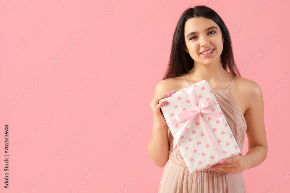 Beautiful young woman with gift for Valentine's day on pink background Beautiful young woman with gift for Valentine's day on pink background