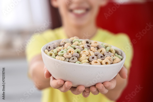 Foto Little boy with bowl of cereal rings at home