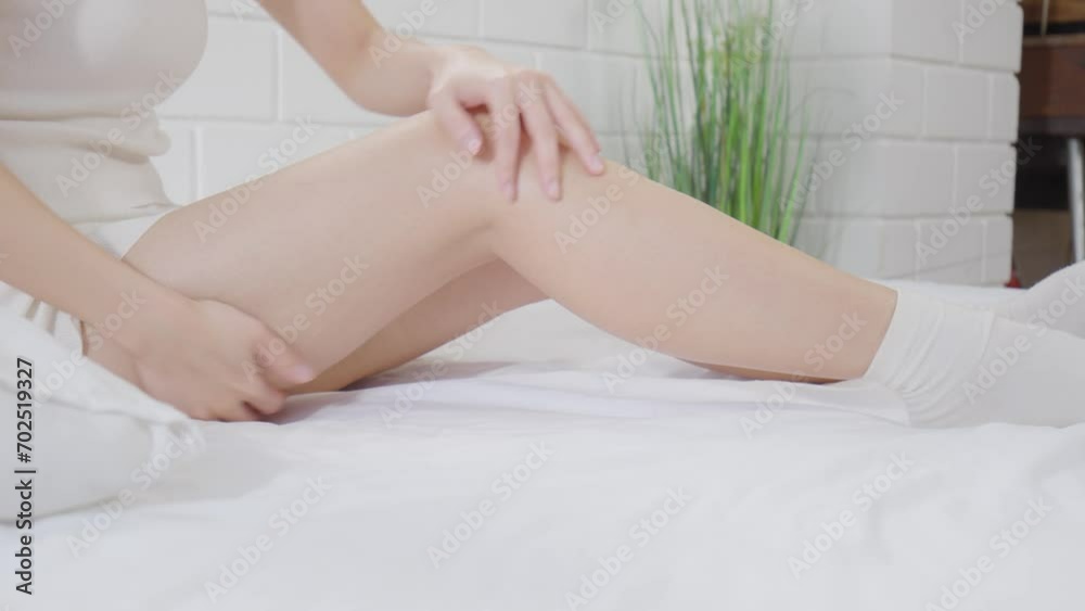 Beautiful Asian young woman apply cream or lotion on her leg for protect dry skin for moisturizing on skin. Healthy skin of young female doing self care at home. Woman self care concept Beautiful Asian young woman apply cream or lotion on her leg for protect dry skin for moisturizing on skin. Healthy skin of young female doing self care at home. Woman self care concept
