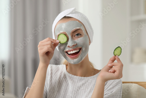 Young woman with face mask and cucumber slices at home. Spa treatments