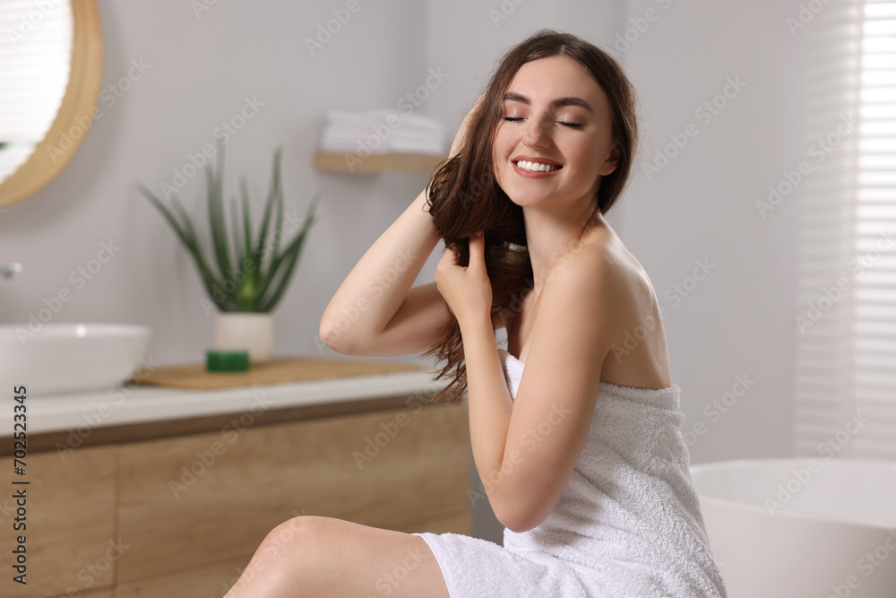 Young woman applying cosmetic hair mask in bathroom Young woman applying cosmetic hair mask in bathroom