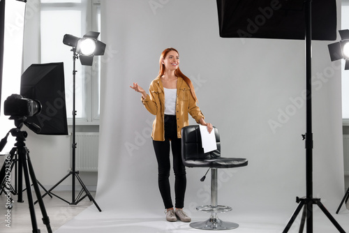 Casting call. Young woman with script performing on grey background in modern studio