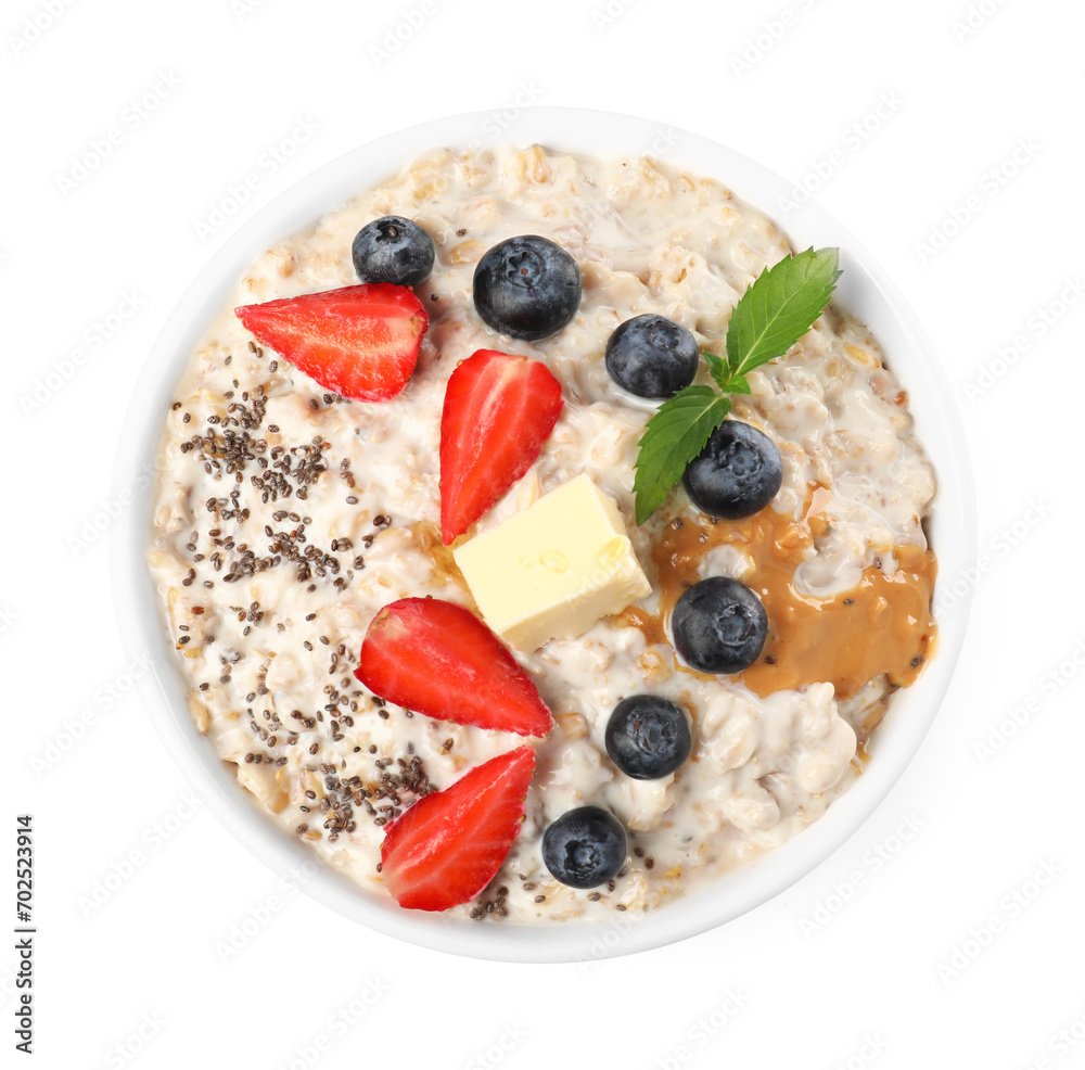 Tasty boiled oatmeal with berries, chia seeds and peanut butter in bowl isolated on white, top view Tasty boiled oatmeal with berries, chia seeds and peanut butter in bowl isolated on white, top view