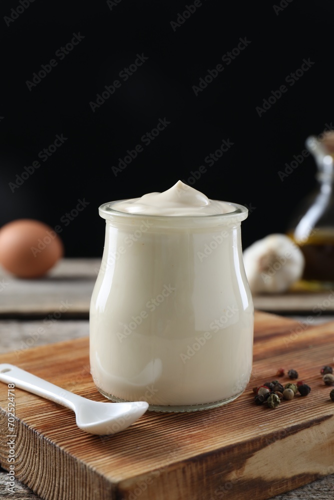 Fresh mayonnaise sauce in glass jar on wooden table, closeup Fresh mayonnaise sauce in glass jar on wooden table, closeup