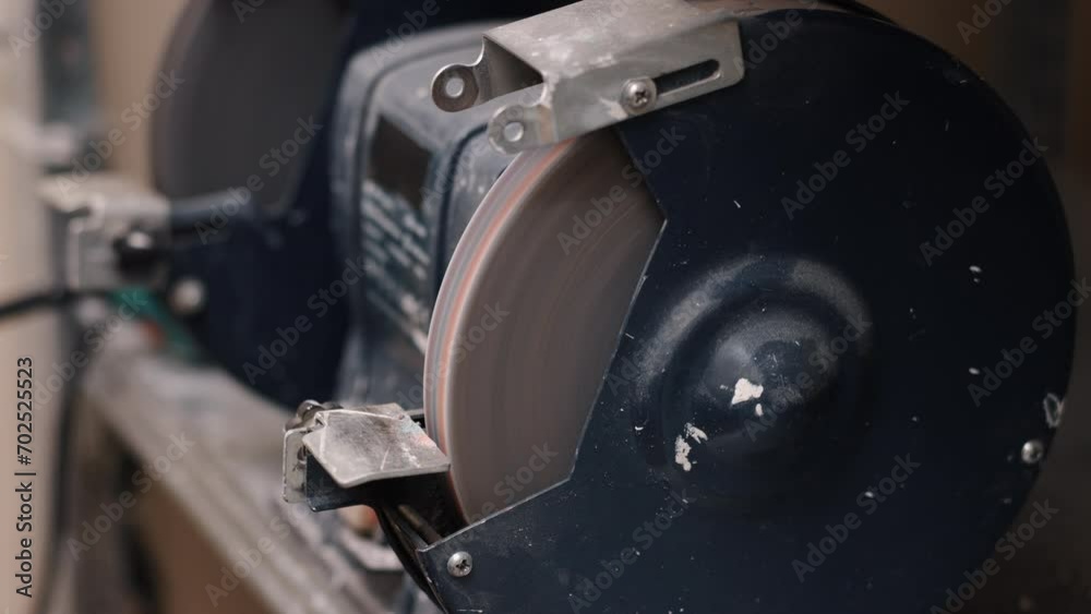 Tool Sharpening, Precision Sharpening, Tool Maintenance. Man meticulously sharpens tool using grinding machine. Tool Sharpening, Precision Sharpening, Tool Maintenance. Man meticulously sharpens tool using grinding machine.