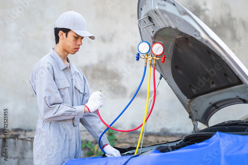 Car air conditioning repair, Technician man checks car air conditioning system refrigerant recharge, Repairman holding monitor tool to check and fixed car air conditioner system