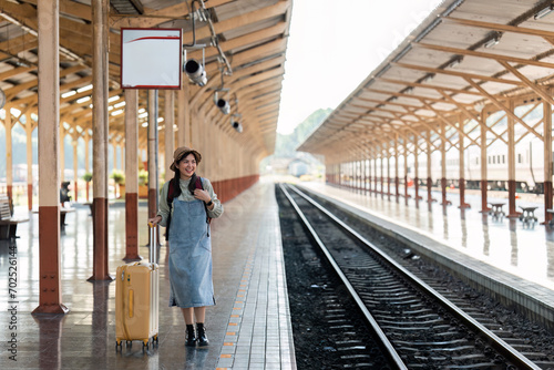 Woman traveler tourist walking with luggage at train station. Active and travel lifestyle concept © itchaznong