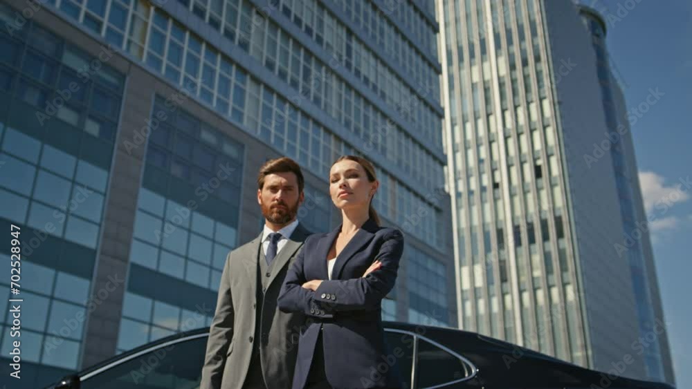 Couple colleagues looking camera on business street. Two business people posing Couple colleagues looking camera on business street. Two business people posing