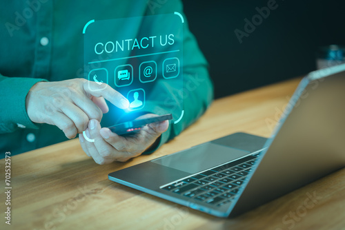 Contact us support hotline, people connect. User man use a smartphone with virtual screen member contact icons ( phone, live chat, email, address ). Customer service, helpdesk advice online support.