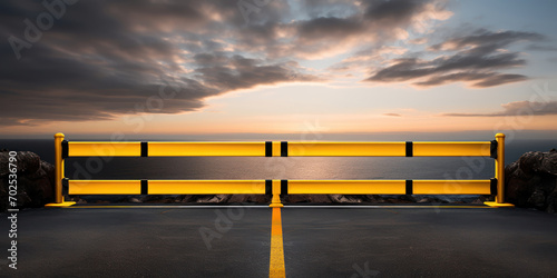 Coastal road barrier painted in bold yellow and black stripes, with a serene ocean horizon photo