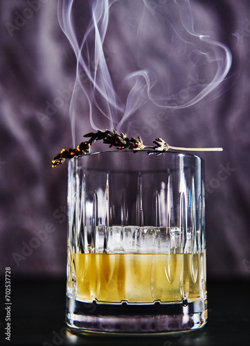 Whiskey cocktail with burnt lavender garnish  photo