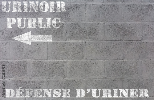 Urinoir public, défense d’uriner, marquage sur mur de parpaings 