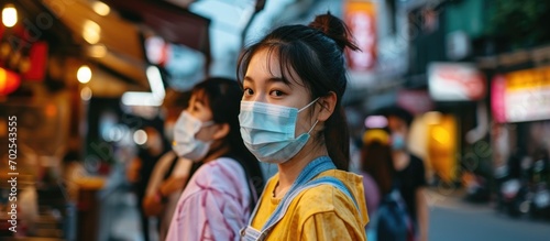 During lockdown, Asian waitresses, wearing masks, provide essential services for takeout and curbside pickup orders amidst the COVID-19 pandemic. © 2rogan