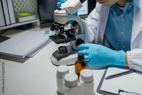 scientist working in the laboratory, scientists conducting research investigations in a medical laboratory, a researcher in the foreground is using a microscope,