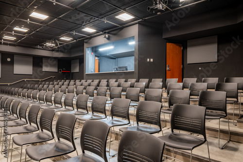 Photo of a new school theater  auditorium  with gray seats  chairs. 