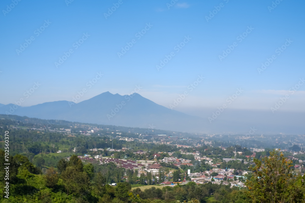 views of Mount Salak and the city of Bogor below with black pollution above the city